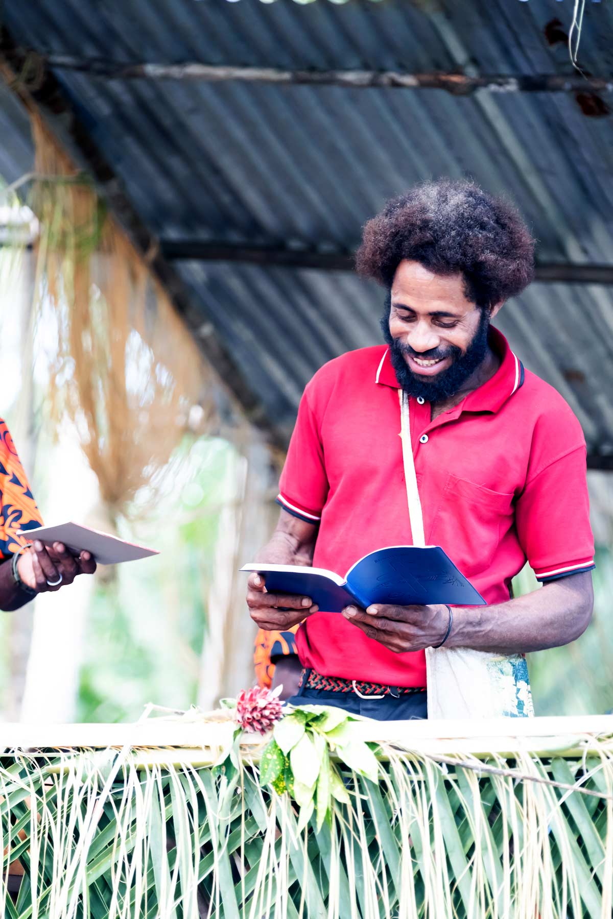 Man smiling with new Yalë New Testament.